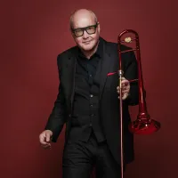Portrait von Nils Landgren mit roter Posaune