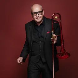 Portrait von Nils Landgren mit roter Posaune